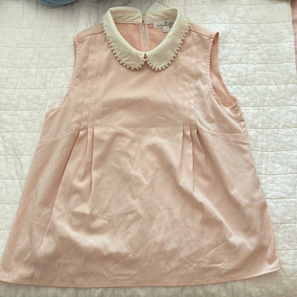 Baby pink sleeveless blouse with pearls on the collar